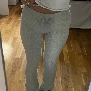 Grå utsvängda mjukisbyxor - Lågmidjade gråa utsvängda mjukisbyxor från Nelly i storlek XXS. Innerbensmått ca 77 midjemått ca 64