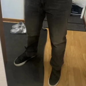 Svarta jeansbyxor med rak passform - Säljer ett par mörkgråa Hugo boss jeans med klassisk rak och stretch passform. Byxorna har fem fickor och normal midja. Perfekta för dig som gillar en enkel och stilren look. Äkthetsbevis finns online, köpt hos Booztlet. I toppskick då de endast testats en gång! Hör av er vid funderingar eller fler bilder!