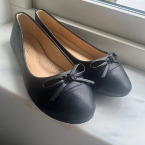 Svarta ballerinaskor med rosett - Säljer ett par svarta ballerinaskor som tyvärr va för stora. De är aldrig använda och är därför i nytt skick💗💗💗