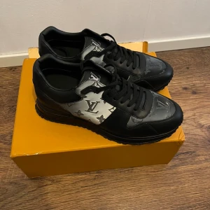 Louis Vuitton skor - Säljer ett par snygga Louis Vuitton sneakers i svart och silver med klassiskt LV-mönster. Skorna har snörning, rund tå och platt sula. Perfekta för dig som vill sticka ut med exklusiva detaljer och lyxig känsla. Helt nya , pris kan diskuteras 