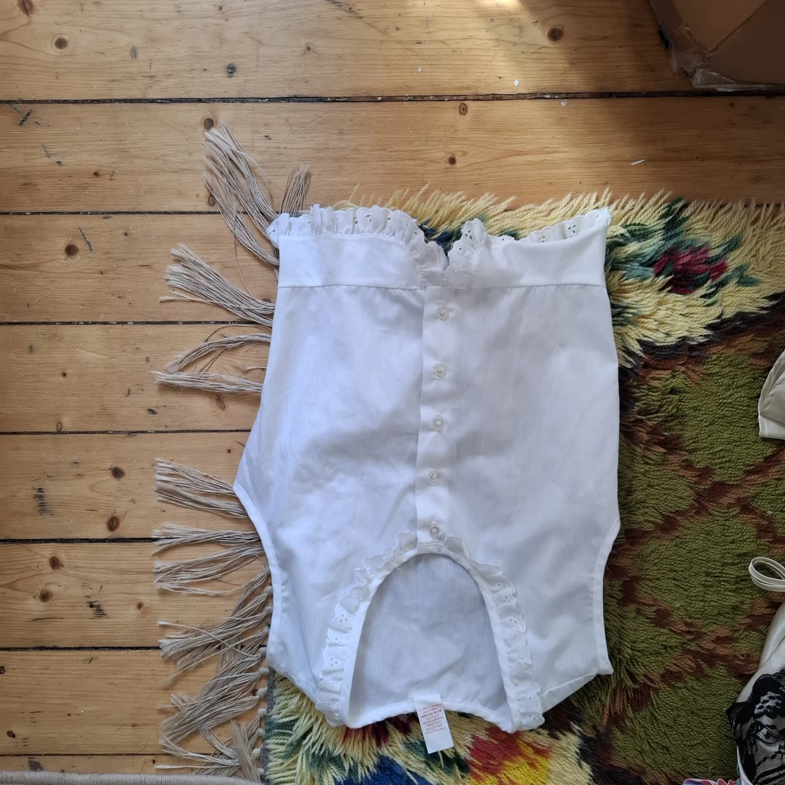 Vit axelbandslös korsett med spets och knappar