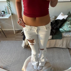 Vita jeans med slitningar - Skit snygga vita jeans med slitningar, funderar på att sälja då de är lite för små tyvärr 🥺💕💕 köptes för 1000 kr, buda ! (Bilder från förra ägaren) midjemått: 37 rakt över 