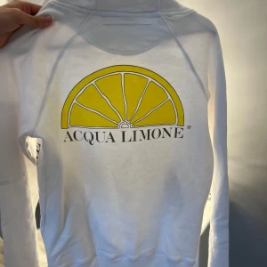 Vit sweatshirt från Acqua Limone - Säljer en vit sweatshirt från Acqua Limone med deras klassiska gula citrontryck framtill och logga på ärmen. Tröjan har rund hals och är tillverkad i mjukt bomullsmaterial. Nypris -1200