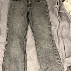 Grå jeansbyxor från Ginatricot - Säljer ett par grå jeansbyxor från Perfect Jeans. Klassisk femficksmodell med dragkedja och knapp i midjan. Raka ben och normal passform, perfekt till vardags. Snygg tvättad grå färg som passar till det mesta. Väldigt bra skick, använder inte längre.