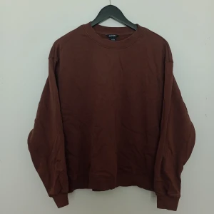 Brun sweatshirt  - Mysig brun sweatshirt från Monki i storlek S. Tröjan har rund halsringning, långa ärmar och är tillverkad i mjukt material. Perfekt för en avslappnad och stilren look.