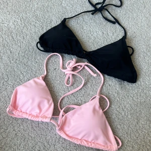 Svart och rosa trekantsbikini - Två trekantsbikinis i svart och ljusrosa med knyt i nacken och ryggen. Klassisk modell med tunna band och enkel design, perfekt för stranden eller poolen.