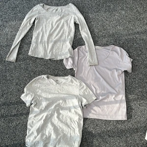 Tre grå t-shirts från 157, Hennes Collection och H&M - Säljer tre stilrena grå t-shirts: en långärmad från 157 i storlek XS, en kortärmad från Hennes Collection i storlek 38/40 och en v-ringad från H&M Basic i storlek 152. Perfekta basplagg till garderoben!