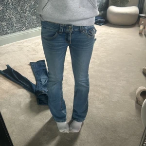 Blå lågmidjade bootcut jeans - Säljer ett par blå jeans med låg midja och bootcut passform. Säljer jeansen billigt eftersom att jag inte andvänder dom här jeansen så ofta