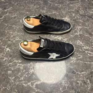 Golden Goose - Säljer ett par otroligt snygga par skor ifrån Golden Goose! Skorna är i väldigt bra skick, skulle säga 9/10 och är i storlek 41. Nypris ligger runt 6000kronor men vi säljer dessa för endast 2299! Skorna är egentligen 41 men är stora i storleken och passar där med 42. Skriv gärna ifall det är några funderingar, allt bästa SkoKapet