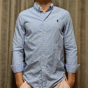 Randig Ralph Lauren Skjorta - En Ralph Lauren skjorta  i Strl XS/S, skjortan håller ett bra skick och killen på bilden är 173 cm lång🙌🏽