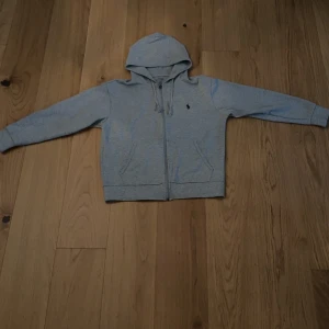 Ralph lauren zip hoodie grå - Säljer nu min grå ralph lauren hoodie då jag inte använder den längre. Den är i perfekt skicka förutom att snörenas metall grej gick sönder när jag tvättade dom för hårt, det är dock inget stort problem och går att fixa billigt. Pris kan diskuteras. Om ni har frågor är det bara att höra av sig 🤗