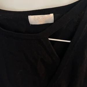 Omlottopp från LeGer - Cool svart omlottopp från LeGer med lång ärm och v-ringad hals. 