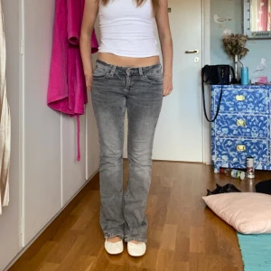 Grå bootcut jeans - Säljer ett par grå lågmidjade bootcut jeans från Gina. de är slitna längst ner då dom är för långa på mig 🥰