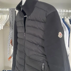 Moncler Cardigan Svart - Säljer nu min Svarta Moncler Cardigan eftersom den börjar bli lite kort på mig, ej använd många gånger och är i toppskick. Perfekt nu under våren och även under sommarkvällarna som kommer. En riktigt stilren och skön jacka som får många blickar mot sig! Söker helst byten mot något fint skicka vad ni har men kan säljas till rätt pris!  Vid minsta fråga kontakta mig, Mvh Kalle! 