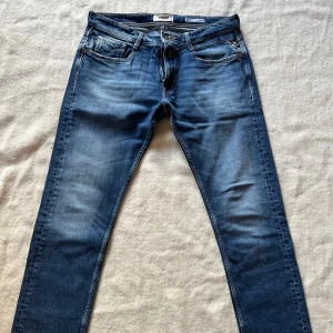 Replay Rocco Comfort Fit Original Stretch Jeans W32 L32 - Säljer ett par helt oanvända klassiska blå jeans från Replay, modell Rocco. Jeansen har normal passform, raka ben och snygga detaljer på bakfickorna. Midjemått W32 och längd L32. Färg är ”Medium Blue”. Ny pris: 1 699kr