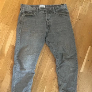 Grå jeans Relaxed Chris Jack and Jones - Säljer ett par grå jeans i modellen Relaxed Chris. Jeansen har klassisk femficksdesign, dragkedjegylf och normal passform med lite lösare ben. Perfekta för en avslappnad stil och passar till det mesta.