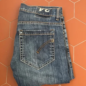 Blå Dondup jeans - Säljer ett par klassiska blå Dondup jeans med raka ben. Jeansen har fem fickor, kontrastsömmar och en unika detaljer. Passar perfekt till vardags och har en tidlös look. Priset kan diskuteras! 😎