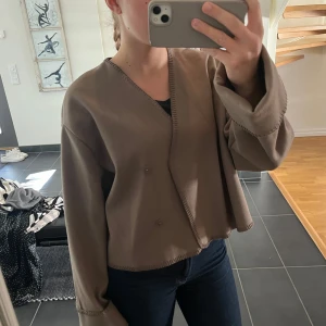Beige croppad omlottjacka - perfekt att dra över en tröja nu till vår/sommar. Knappt använd!