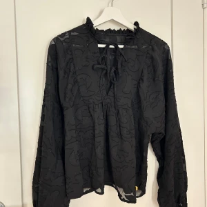 Svart blus med knytning  - Säljer en super fin svart blus från Pernilla Wahlgrens kollektion
