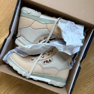 Beige boots från FILA - Snygga beige boots från FILA med robust sula och snörning. Använda några få gånger men säljer pga av att dom bara står i garderoben, vilket dom inte förtjänar..! 