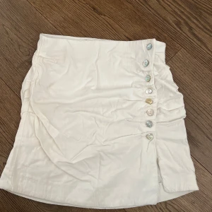 Vit kortkjol med pärlemorknappar - Säljer en vit minikjol från Zara🫶🏽🫶🏽🫶🏽🫶🏽