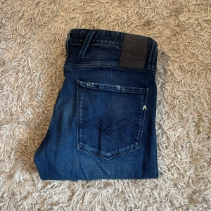 Mörkblå Replay Anbass jeans slim fit grisch laidback  - Säljer ett par mörkblå Replay Anbass jeans med klassisk femficksdesign och snygga slitningar. Mycket bra skick, inga märkvärda anmärkningar. Storlek 32/34 mått kan såklart skickas vid osäkerhet. Riktigt mjuka och stretchiga i materialet. Postas antigen samma dag som köp eller dagen därpå, sänker priset 50kr vid snabb och smidig affär 💯🙌