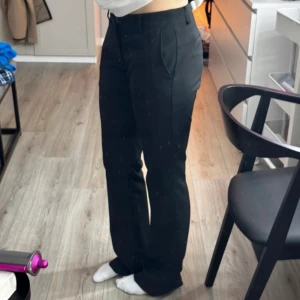 Lågmidjade kostymbyxor bootcut  - Lågmidjade utsvängda kostymbyxor i modellen Vera från Bikbok, medium längd! Innerbenslängd ca 82cm