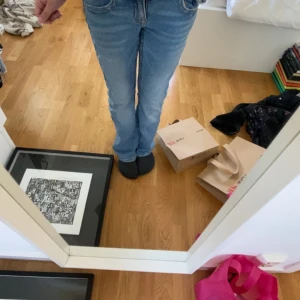 Blå bootcut jeans - Säljer ett par klassiska blå bootcut jeans med normal passform. Jeansen har fem fickor, dragkedja och knapp framtill. Perfekta för dig som gillar en tidlös stil med lite utsvängda ben.