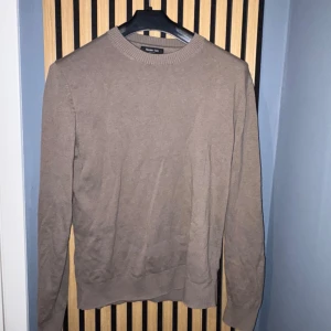 Beige stickad tröja från Massimo Dutti - Säljer en stilren beige stickad tröja från Massimo Dutti. Tröjan har rund halsringning och långa ärmar med ribbade muddar. Perfekt för lager-på-lager och enkel att matcha med olika outfits.