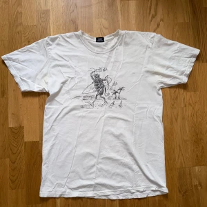 Stüssy t-shirt 2018 - Säljer en vit t-shirt från Stüssy med ett coolt tryck på framsidan och text på baksidan. Perfekt för en avslappnad stil. Tillverkad i Mexiko. Köpt från deras hemsida 2018. 