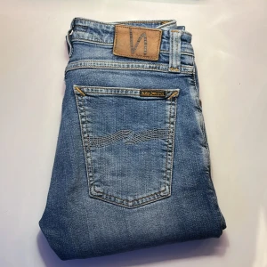 Blå jeans från Nudie Jeans - Först till kvarn‼️Snygga blå jeans från Nudie Jeans med klassisk femficksdesign och en bekväm passform. De har en diskret tvättad look och märkets ikoniska broderi på bakfickorna. Perfekta för en avslappnad stil. Priset kan självklart diskuteras. Frågor eller funderingar? Kontakta mig | OBS! Bilderna från han byxorna köptes av!