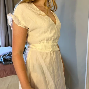 Vit klänning med knytband - Säljer denna så gulliga klänningen med volanger och knytning i midjan, så att man kan knyta den lite hur man vill 🩷Perfekt som studentklänning, skolavslutningsklänning eller bara till sommaren🥰