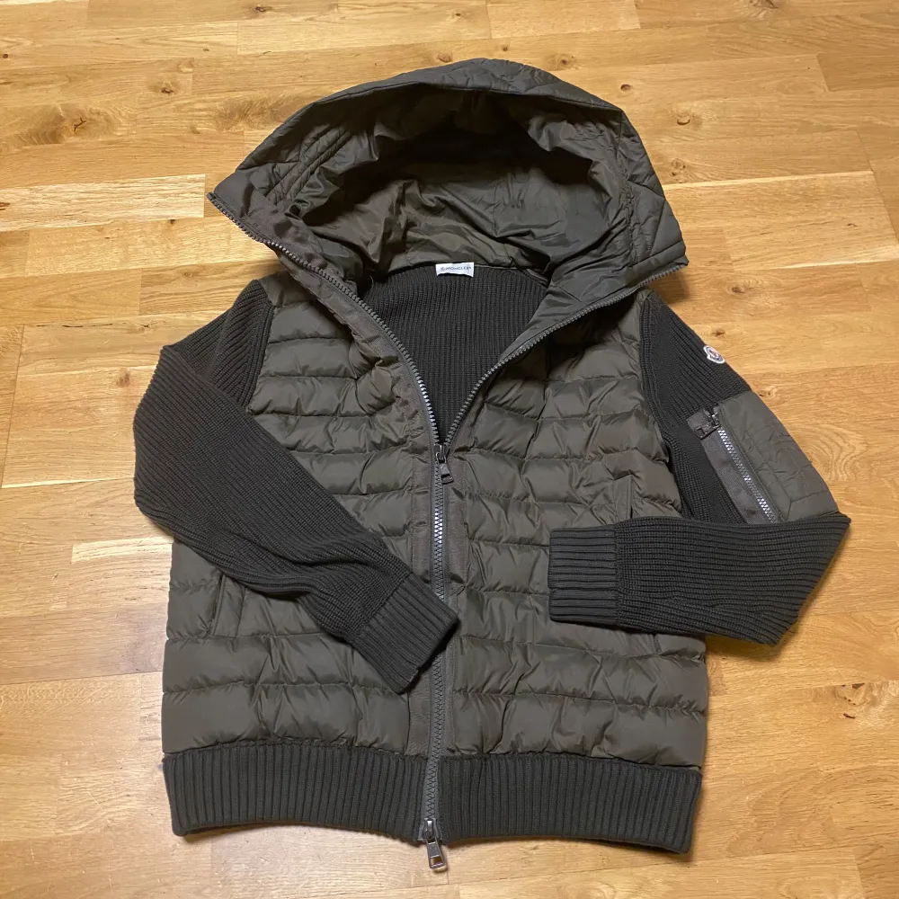 Snygg olivgrön jacka från Moncler med quiltad design och huva. Jackan har långa ärmar i ribbat material och dragkedja framtill. Perfekt för kyligare dagar. Jackan är i storlek L men sitter lite tajt så skulle nog säga att den passar mer som M. Har du minsta lilla fundering så är det bara att fråga på.. Takit.