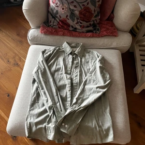 Grön skjorta från East West - Snygg grön skjorta från East West i slim fit. Skjortan har långa ärmar och knappar framtill. Perfekt för en stilren look.