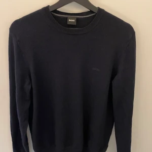 Mörkblå tröja från BOSS - Snygg mörkblå tröja från BOSS med rund halsringning och diskret logga på bröstet. Perfekt för en stilren look👍🏽. Den är i Medium men liten i storlek så skulle säga att den är mer mot S hållet. Använts runt 7 gånger med 1 tvätt.