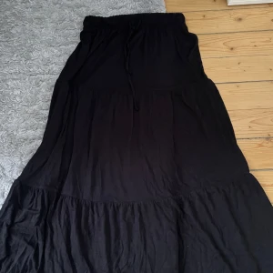 Svart långkjol från Pieces - Snygg svart långkjol från Pieces med elastisk midja och dragsko. 