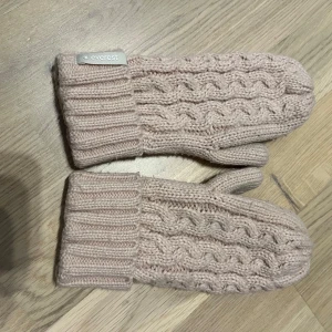 Beige stickade vantar från Everest - Säljer ett par mysiga beige stickade vantar från Everest. De har ett flätmönster på ovansidan och ribbstickade muddar för extra värme. Perfekta för kalla dagar! 🧤