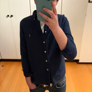 Ralph lauren skjorta (160) - Säljer nu min sjukt snygga skjorta från Ralph lauren. Den är i mycket bra skick och är i storlek 10-12 men modellen är 166 så skulle säga att den passar någon mellan 150-160 då den är lite liten på han. Hör av dig vid funderingar 