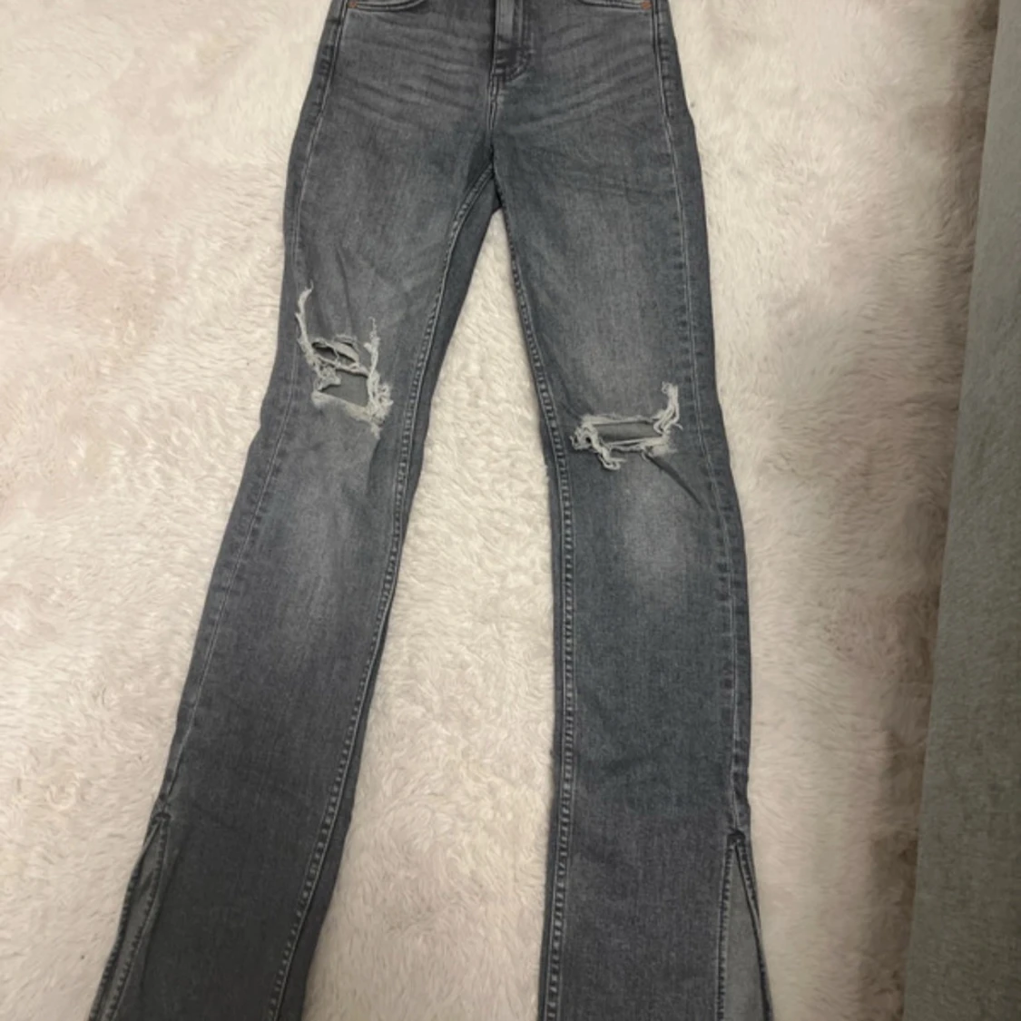 Grå jeans med slitningar