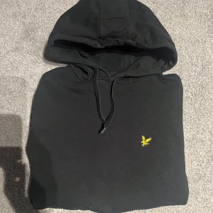 Svart hoodie från Lyle & Scott - Säljer en svart hoodie från Lyle & Scott. Tröjan har inga defekter men är lite skrynklig. Nypris - 800kr och den har inte används mycket. 