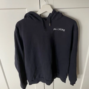 Hoodie - Säljer min marinblåa hoodie får Gina tricot med texten 'Ma Chérie' i vitt på både fram- och baksidan. Hoodien är använda få gånger och är i mycket bra skick, men har tappat bort ena knoppen på snöret. Hoodien är storlek 158/164 och säljer den för 90kr 💕