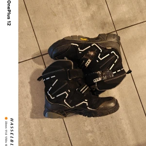 Svarta och grå vinterkängor från McKinley - Säljer ett par robusta vinterkängor från McKinley i svart och grått. Modellen Snowstar II har en slitstark design med dragkedja och kardborreband för enkel på- och avtagning. Perfekta för kalla vinterdagar med en varm och bekväm insida.