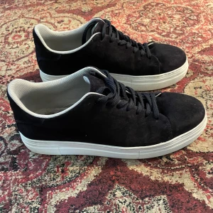 Mörkblåa mocka skor från Selected Homme - Snygga mörkblåa sneakers i mocka från Selected Homme. Vit sula med det stilrena märket undertill. Nypris - 1199kr                                                                        Pris kan diskuteras
