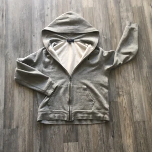 Grå hoodie från Polo Ralph Lauren - Säljer en grå unisex hoodie från Polo Ralph Lauren med dragkedja och huva. Den har en broderad logga på bröstet i blått. Perfekt för en avslappnad stil. Storlek XL i junior vilket motsvarar S så jag skulle säga att den passar allt mellan 165-175. ⚠️Vid snabb affär är priset ej hugget i sten!⚠️Mvh Arre_Sellout🍀