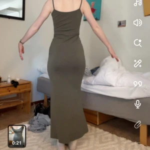 Olivgrön långklänning - Snygg olivgrön/ militärgrön långklänning med smala axelband och figurnära passform. Perfekt för en stilren look. Passar även S.