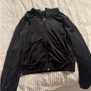 Svart mjukiströja med dragkedja - Snygg svart mjukiströja med dragkedja och huva. Jackan har långa ärmar och praktiska fickor framtill. Perfekt för en avslappnad stil. Storlek M. 95% polyester 5% elastan. Lite använd. Hör av dig för eventuella frågor 🌸kolla gärna in mina andra annonser!⤵️✨