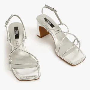 Silvriga sandaler med klack från M&S - Stilrena silvriga sandaler från M&S med smala remmar och fyrkantig tå. De har en elegant klack och justerbart spänne runt ankeln. Perfekta för en glammig look. Jag har tidigare klistrat fast en mjuk dyna under tårna men kan ta bort den om så önskas, annars är den enkel att ta plocka bort själv ifall du önskar testa med.