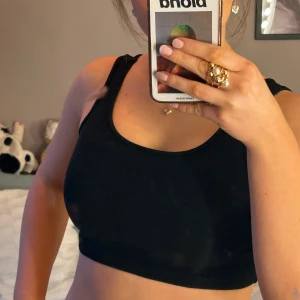 Svart linnetopp från Gina Tricot - Säljer en stilren svart linnetopp från Gina Tricot i storlek XS. Toppen har en enkel design med breda axelband och är kort i längden! 