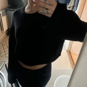 Svart croppad tröja - Säljer denna croppade tröjan med utsvängda armar från Monki! Tröjan är i storlek S, och använd några gånger men är fortfarande i väldigt bra skick💕
