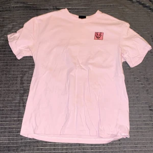 Rosa t-shirt med tryck - Säljer en rosa keith haring t-shirt från hm.